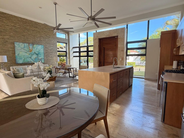 Modern open-plan living and kitchen area with large windows and island