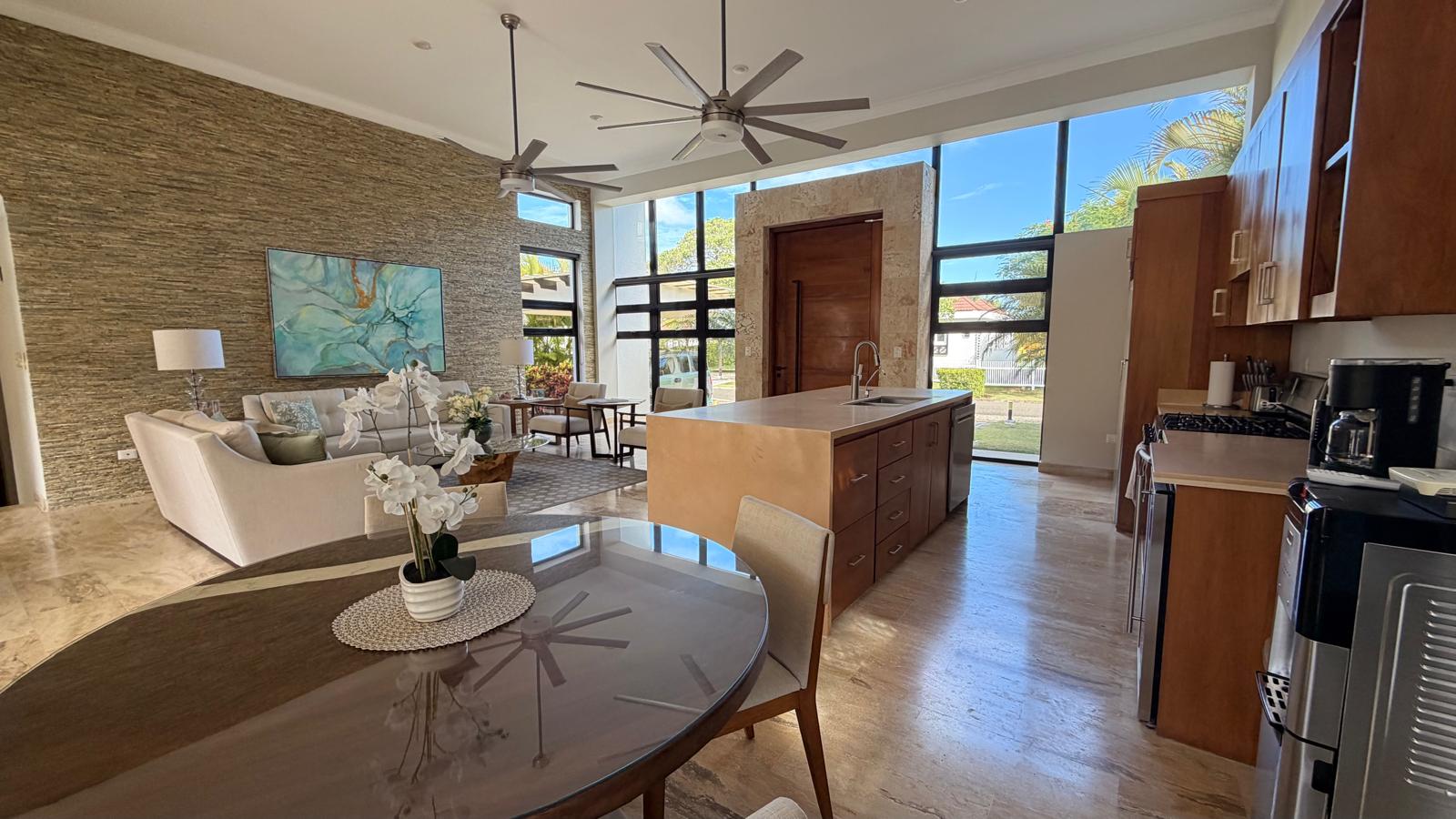 Modern open-plan living and kitchen area with large windows and island