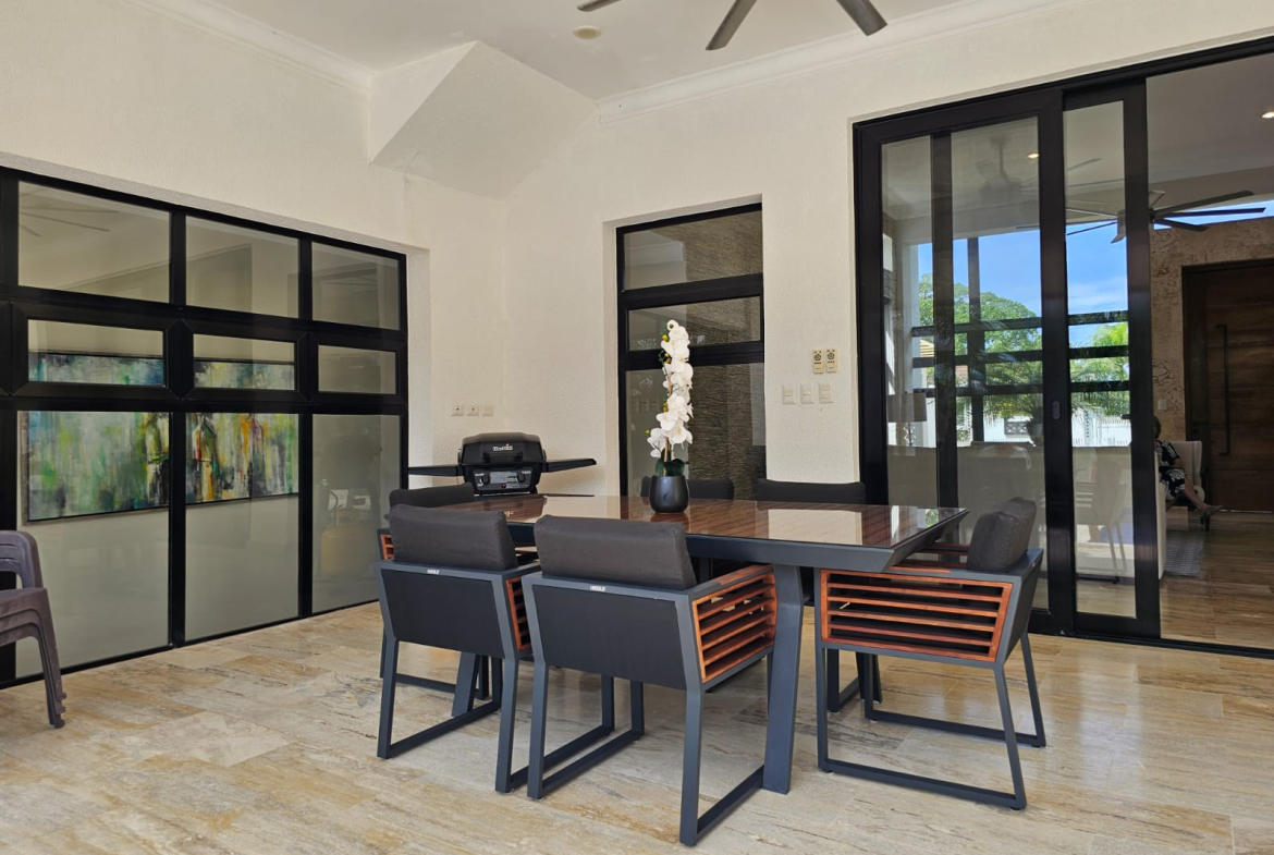 Modern outdoor dining set with chairs and table on a tiled patio