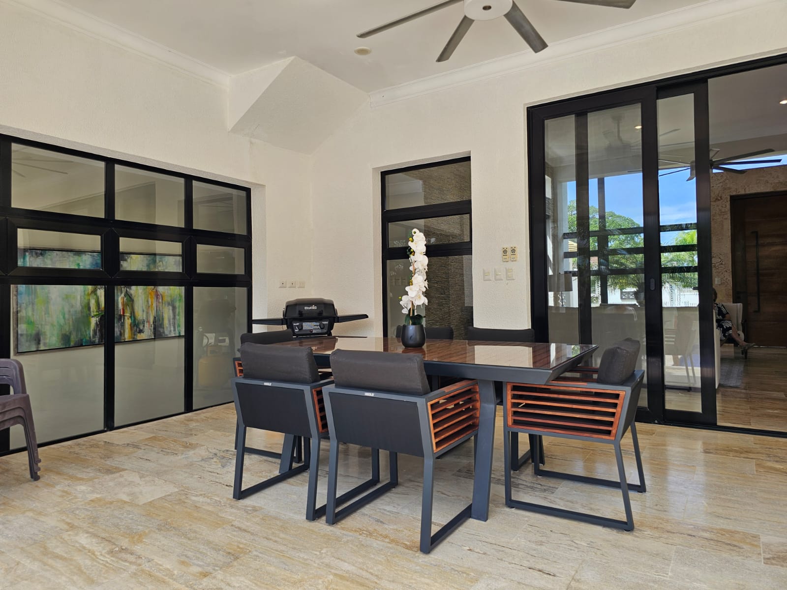 Modern outdoor dining set with chairs and table on a tiled patio