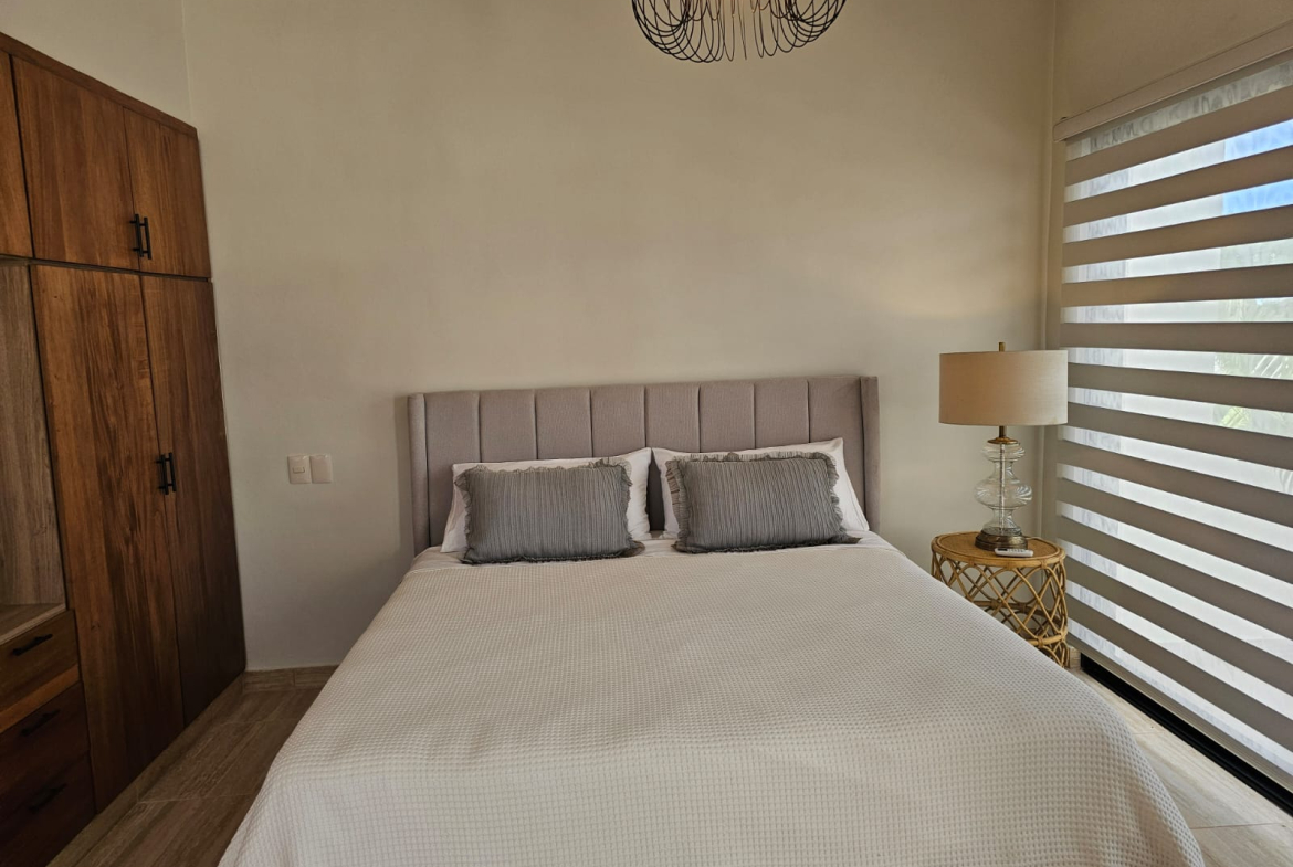 Modern bedroom with a queen bed, nightstand, and wood wardrobe