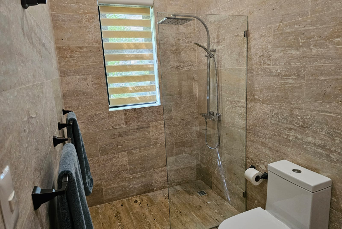 Modern bathroom with glass-enclosed shower and tiled walls