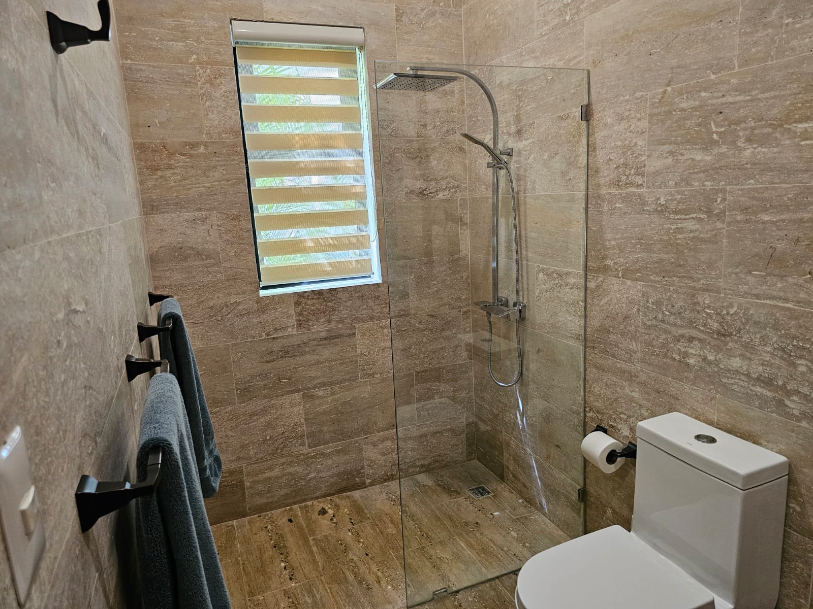 Modern bathroom with glass-enclosed shower and tiled walls