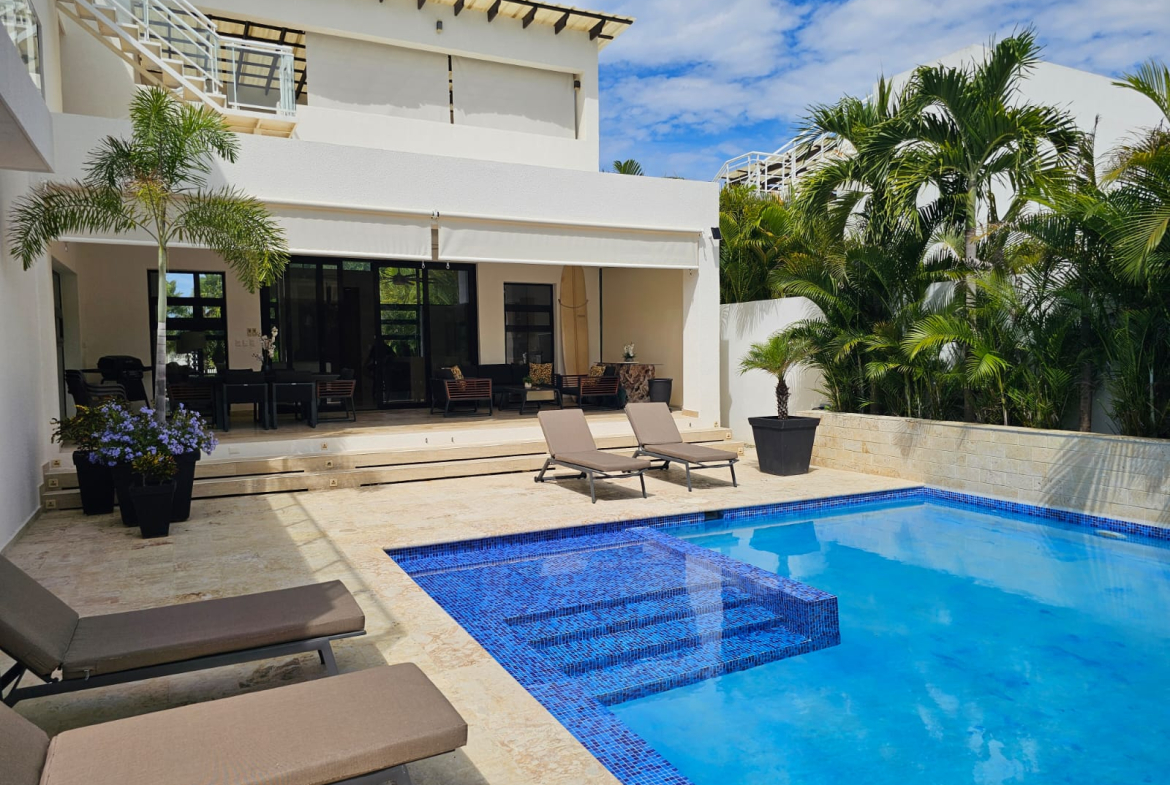 Modern villa with a blue tiled swimming pool and lounge chairs.