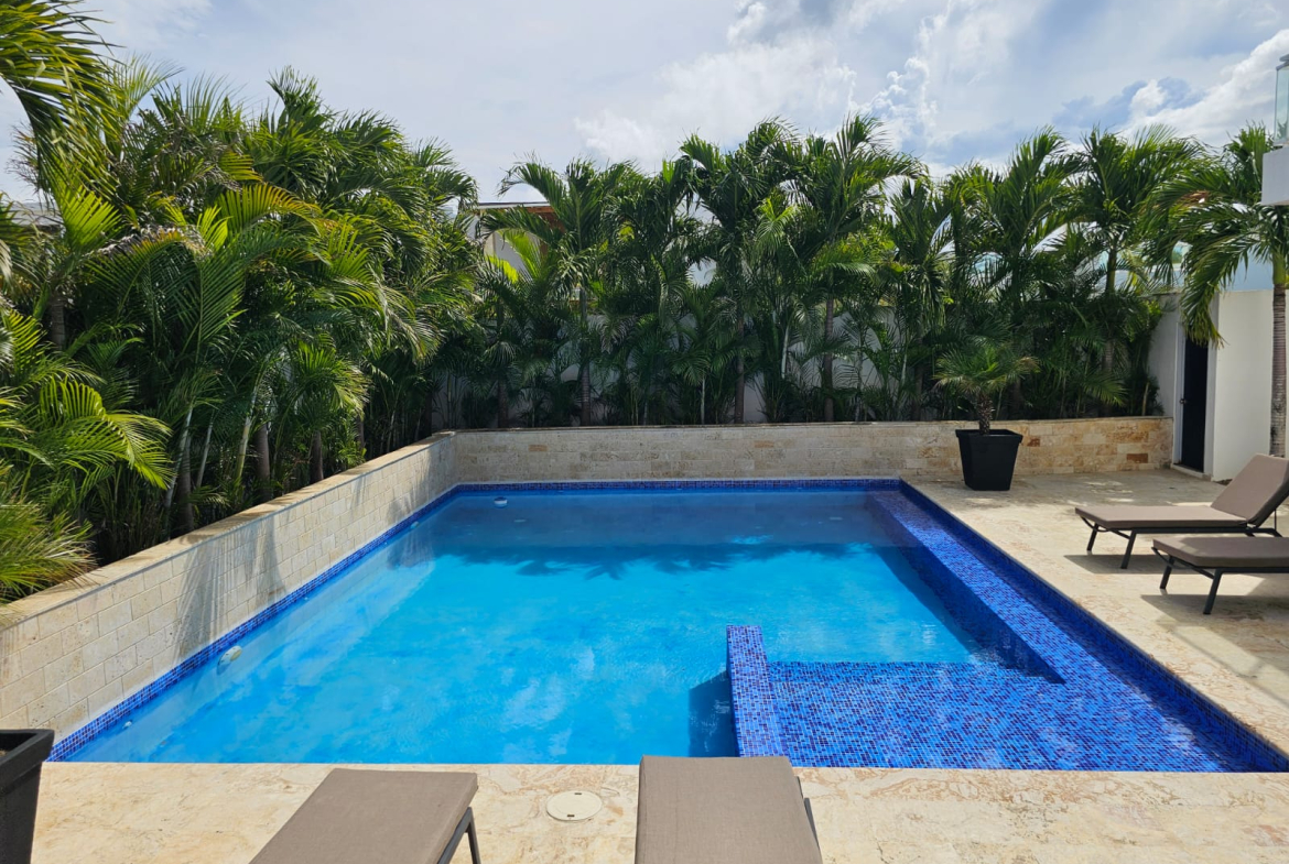 Luxury swimming pool with lounge chairs and palm trees