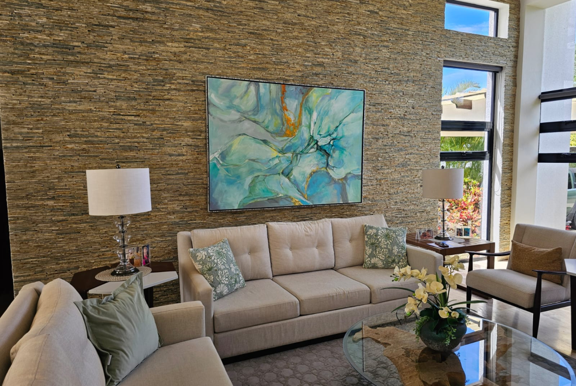Modern living room with textured stone wall, abstract art, and comfortable seating.