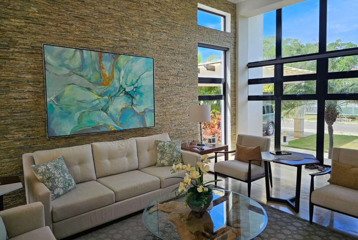 Modern living room with abstract art, stone accent wall, and large windows