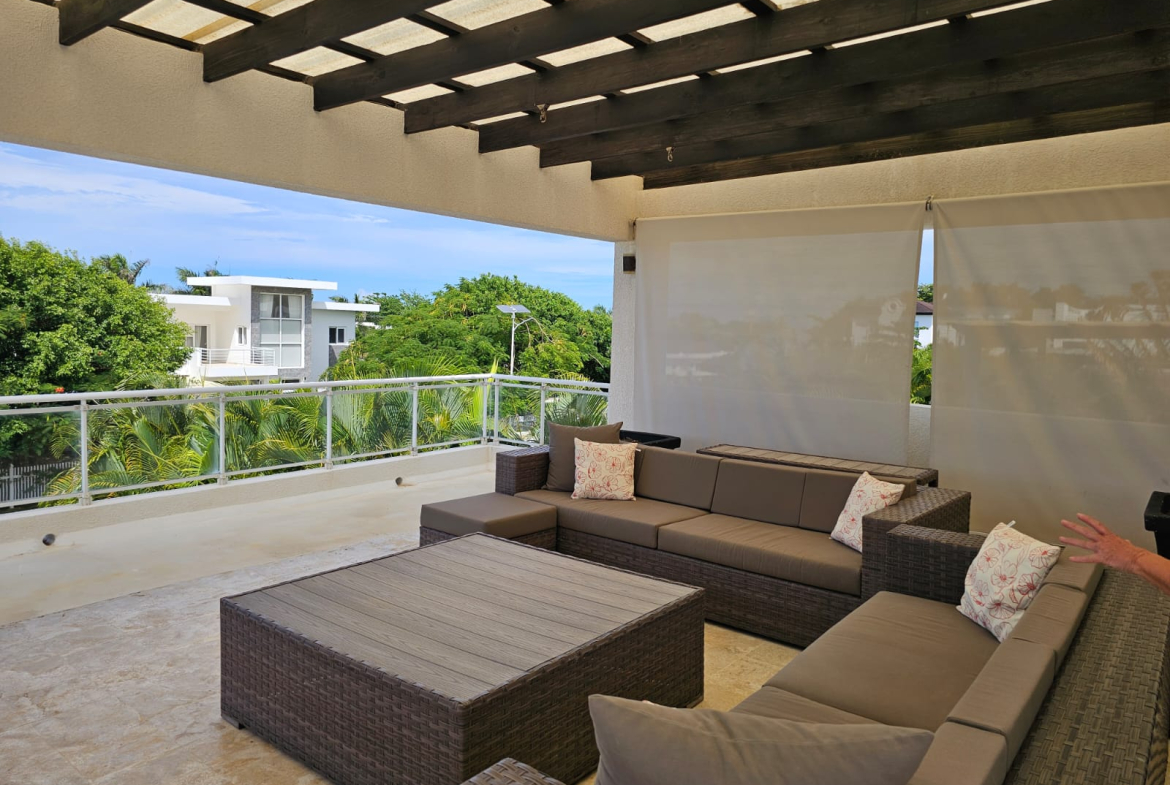 Modern outdoor living space with sectional sofa, coffee table, and ocean view