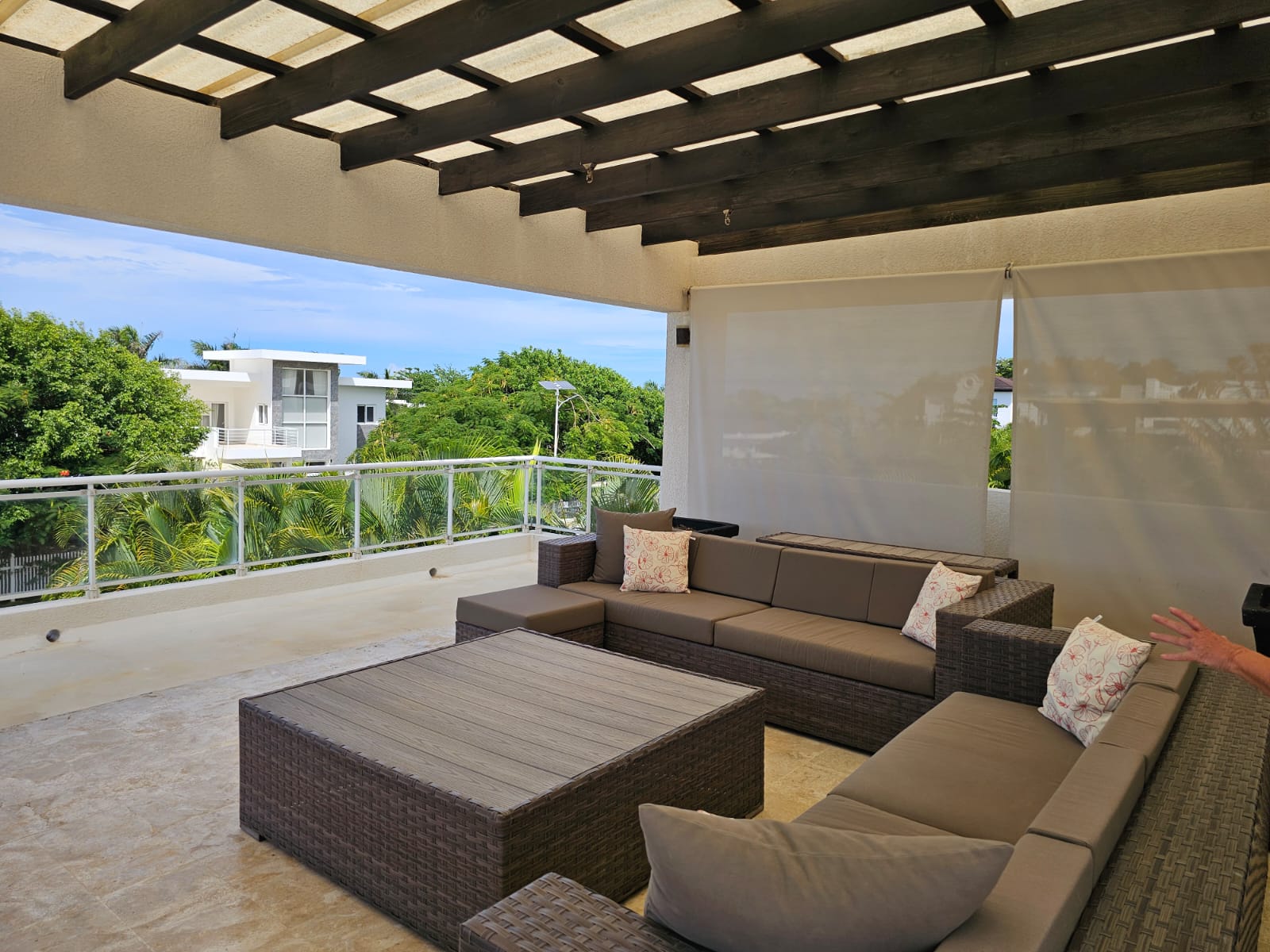 Modern outdoor living space with sectional sofa, coffee table, and ocean view