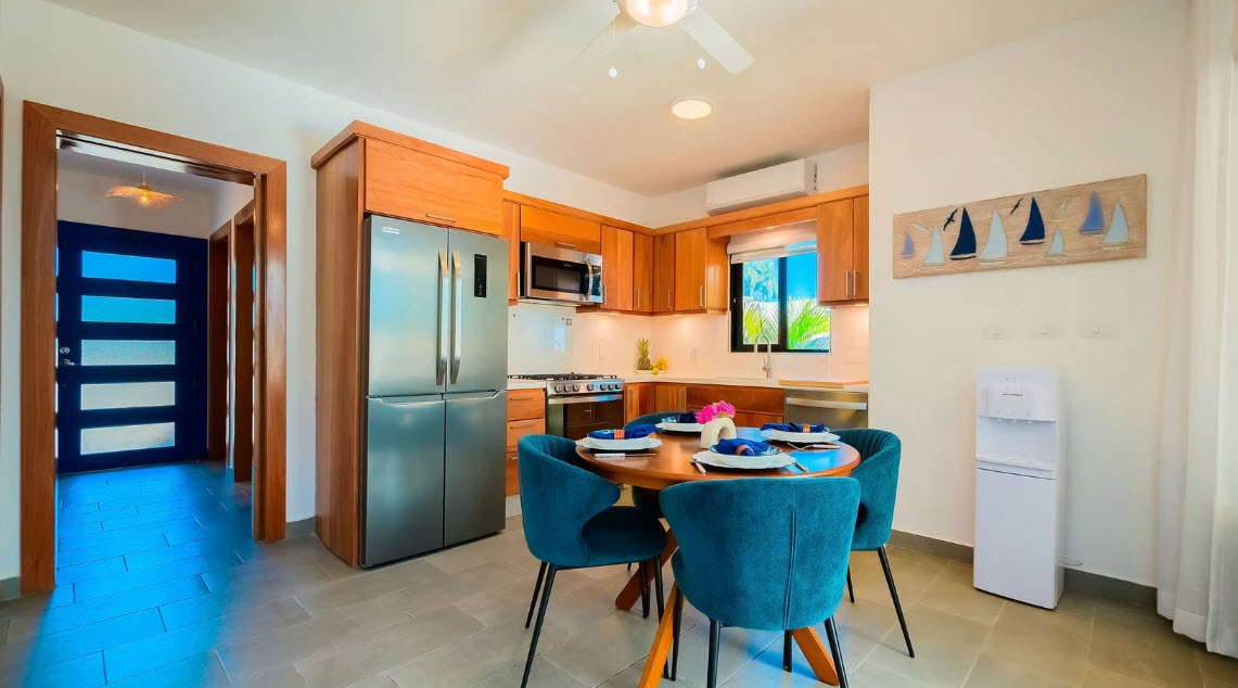 Modern kitchen and dining area with blue chairs and a wooden table