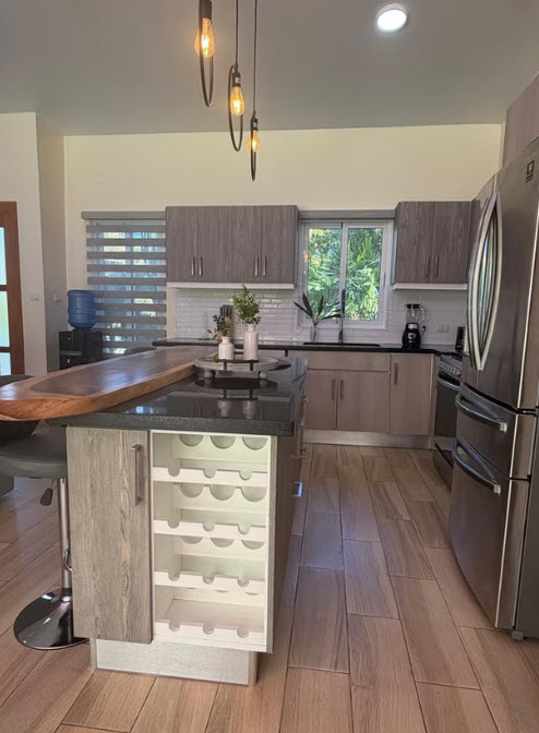 Modern kitchen with island, wine rack, and stainless steel appliances