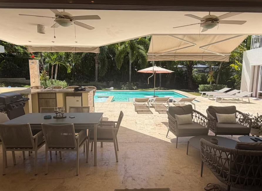 Luxurious outdoor patio with pool, dining area, and lounge chairs