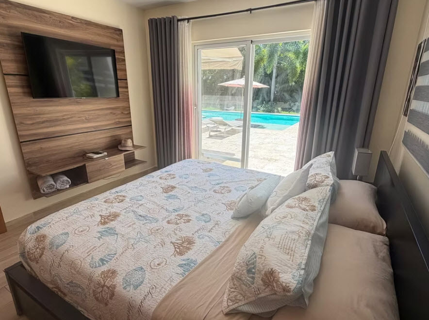 Bedroom with queen bed and view of tropical pool area