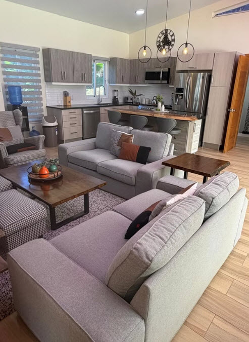 Modern living room and kitchen with gray sectional sofa and island