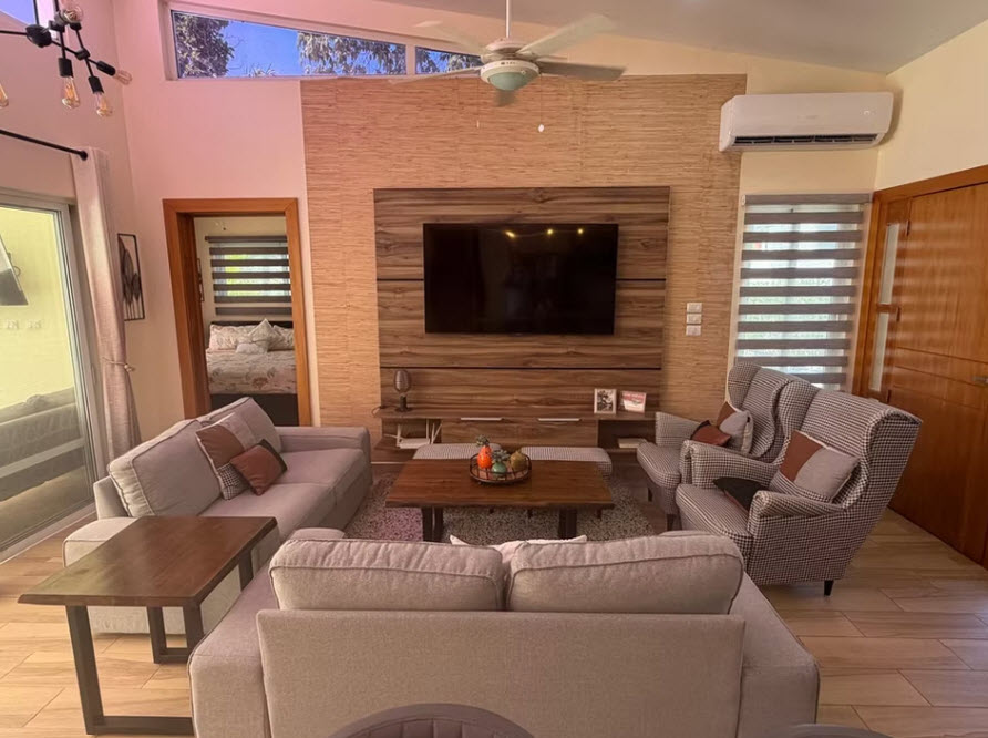 Modern living room with sectional sofa, accent chairs, and large TV