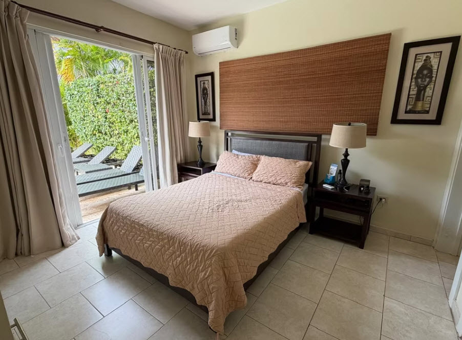 Comfortable bedroom with a queen bed, bedside tables, and patio access