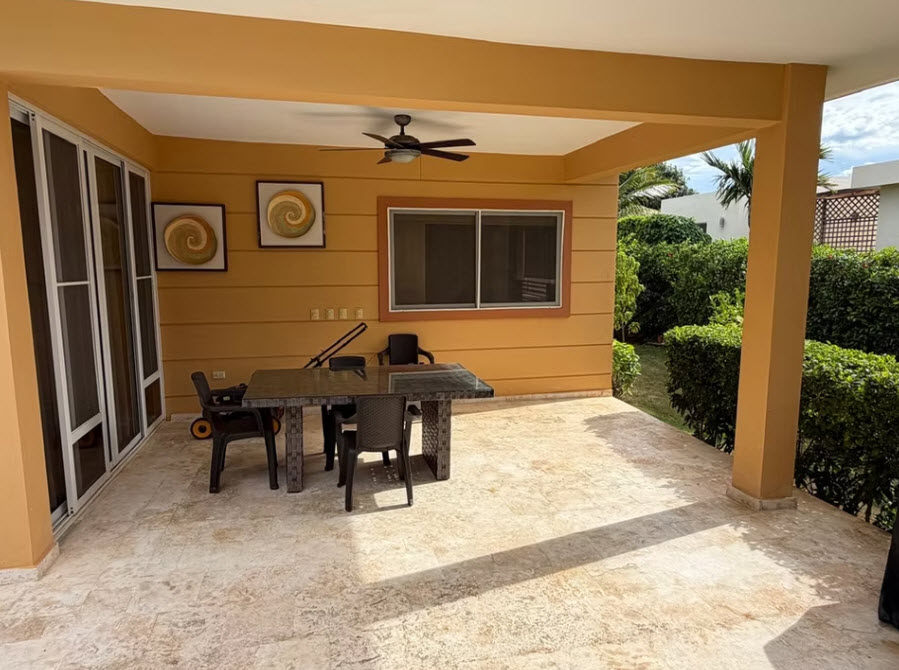 Outdoor patio with table, chairs, and lawnmower