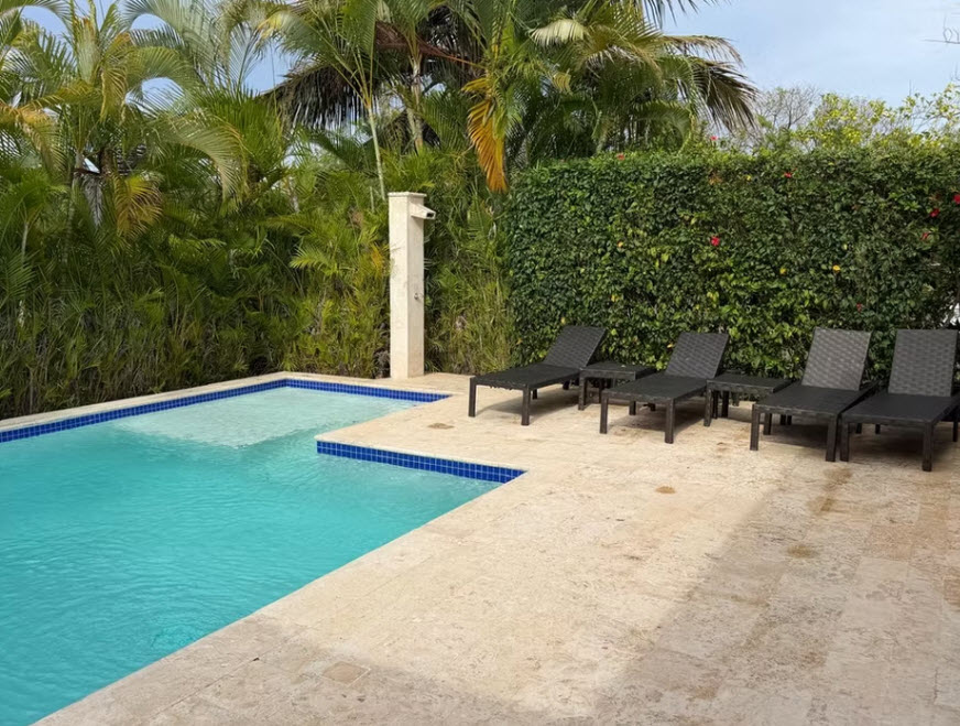 Luxury resort pool with lounge chairs and palm trees