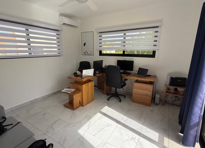 Modern home office with dual workstations, natural light, and minimalist decor.