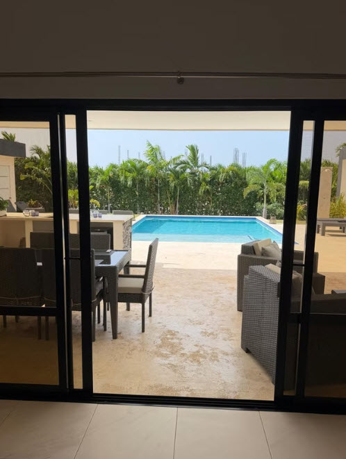 Luxury villa patio with swimming pool, lounge chairs, and outdoor dining area