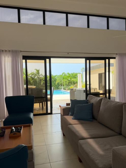 Spacious living room with view of private pool and tropical foliage in Caribbean villa