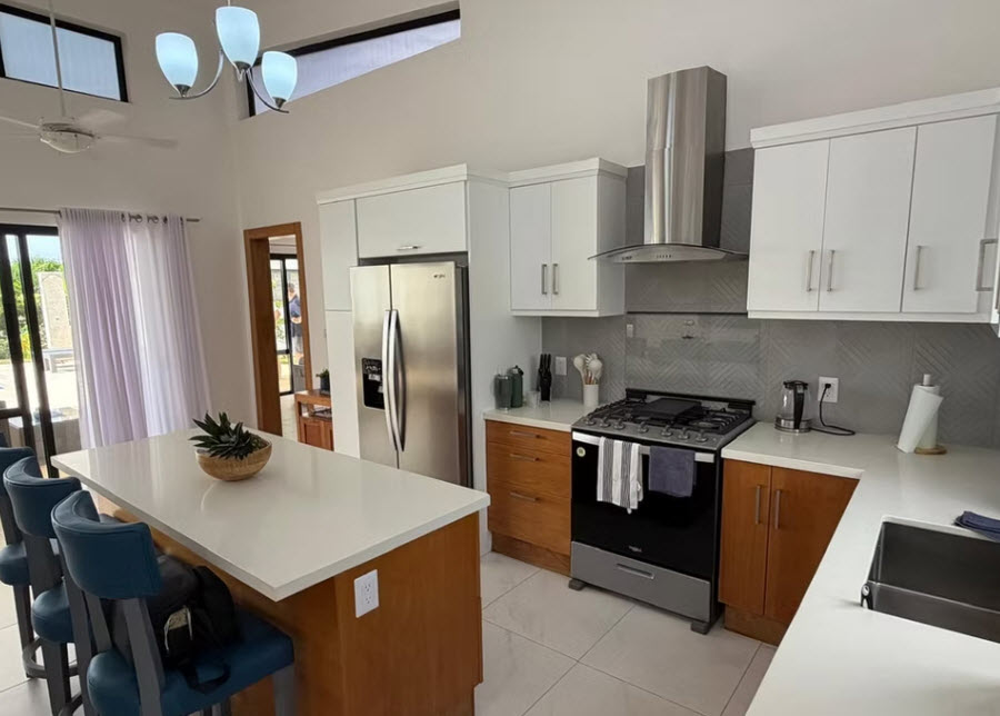 Modern white and wood kitchen with stainless steel appliances and island