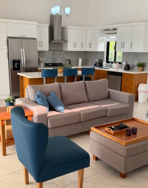 Modern living room and kitchen with neutral tones and blue accents