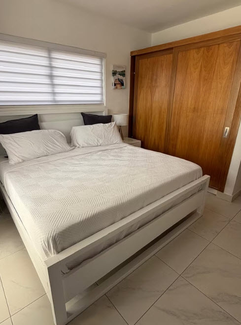 Modern white bed with wood closet in bright bedroom