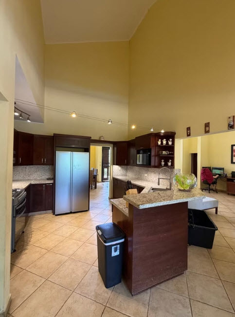 Spacious modern kitchen with island, stainless steel appliances, and high ceilings