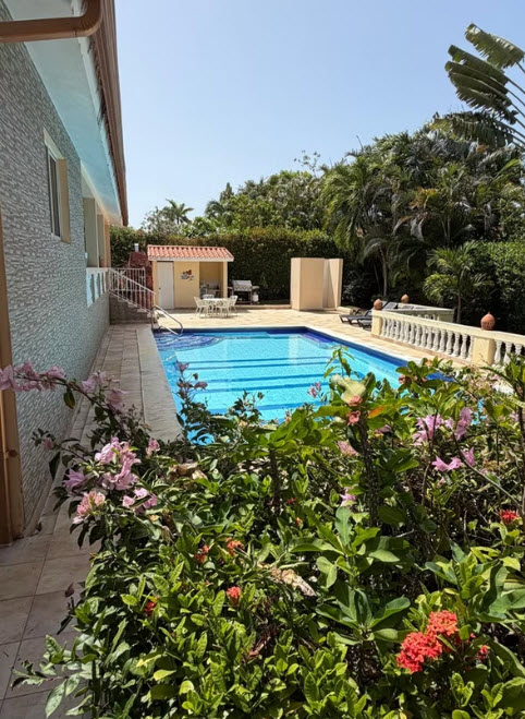 Luxury villa with pool, outdoor dining, and lush tropical gardens