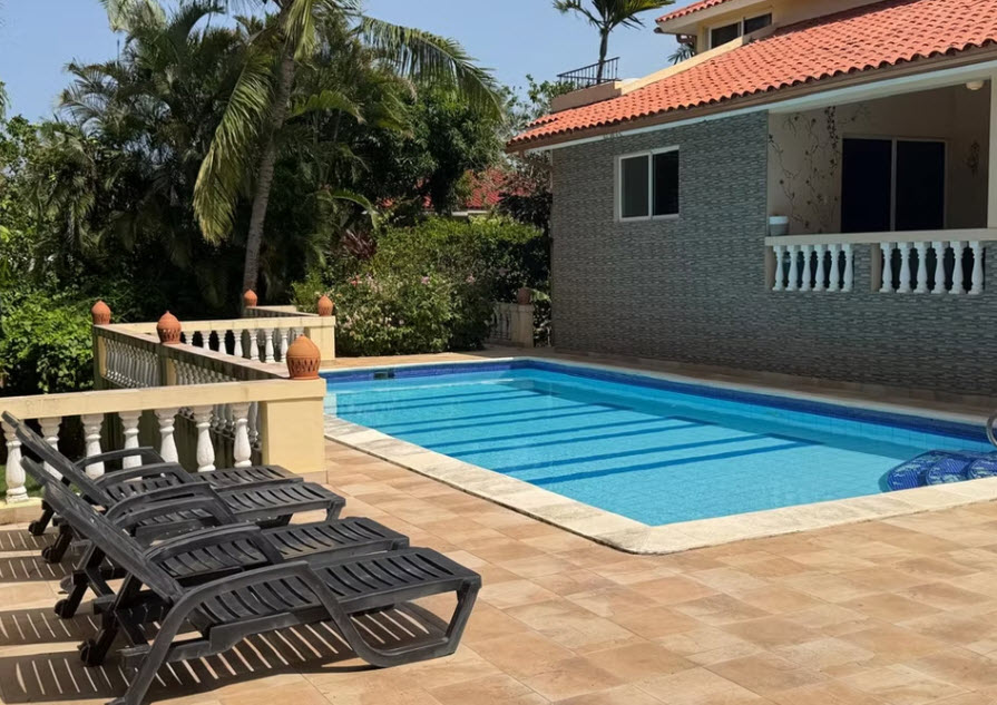 Luxury villa with swimming pool and lounge chairs in a tropical setting