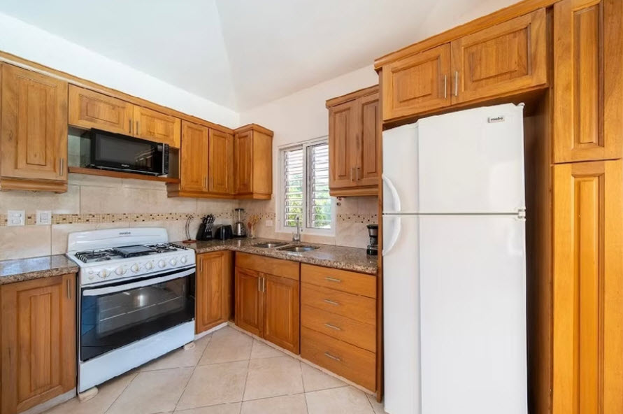 Warm wooden kitchen with white stove and refrigerator