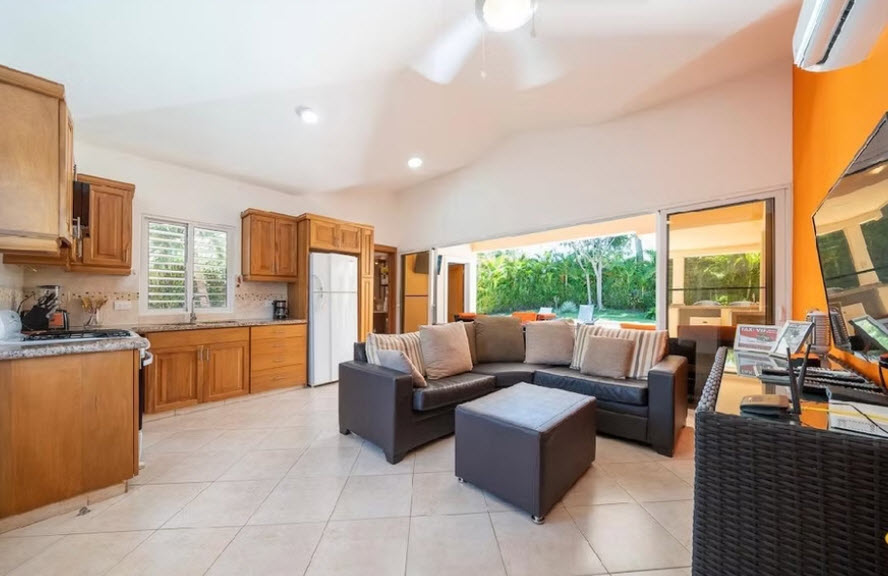 Spacious living room and kitchen with sectional sofa, island, and outdoor view
