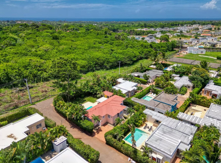 Aerial view of a tropical residential community with houses and swimming pools