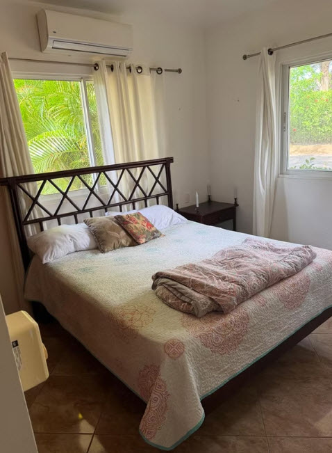 Cozy bedroom with a queen-size bed, tropical view, and air conditioning
