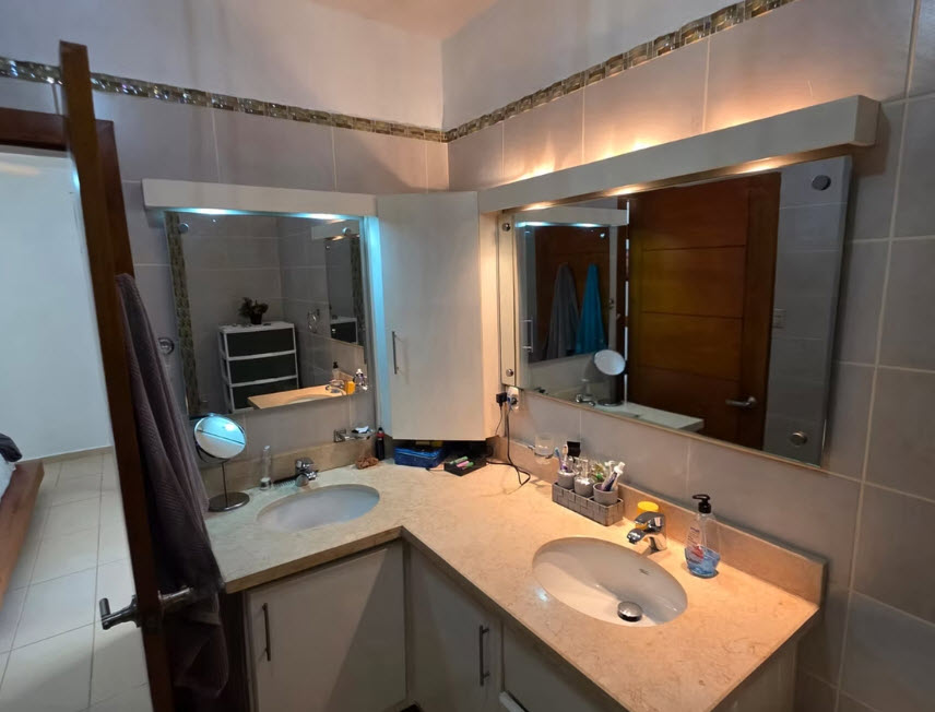 Modern bathroom vanity with double sinks, mirrors, and toiletries