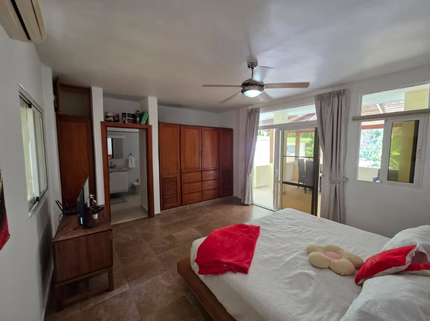 Spacious bedroom with king-size bed, wooden wardrobes, and balcony access