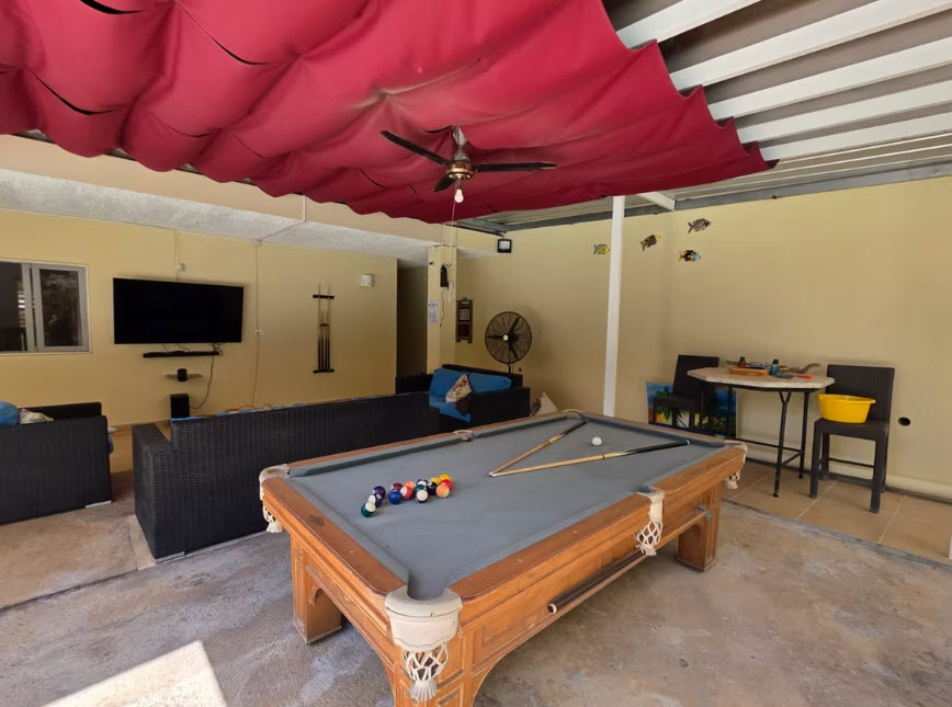Pool table and seating area in a covered outdoor entertainment space