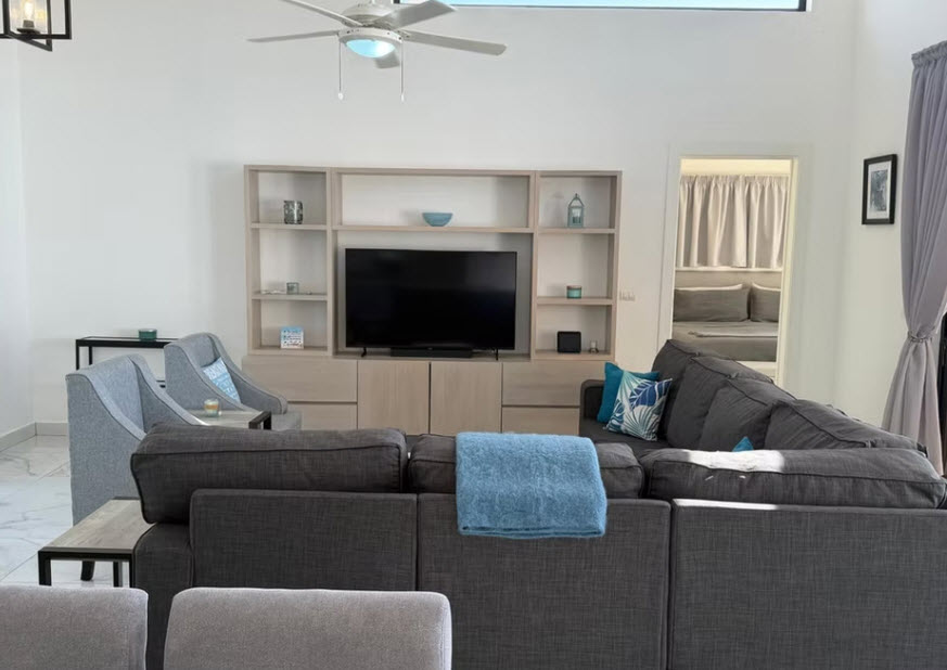 Spacious modern living room with large sectional sofa and entertainment unit