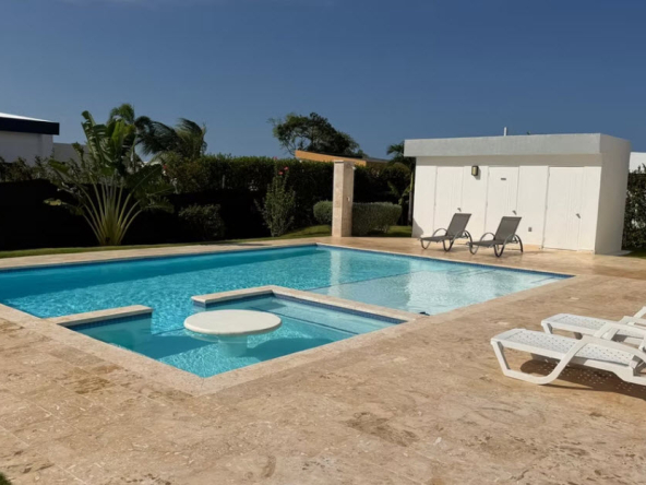Luxury swimming pool with swim-up bar and lounge chairs in a tropical setting.