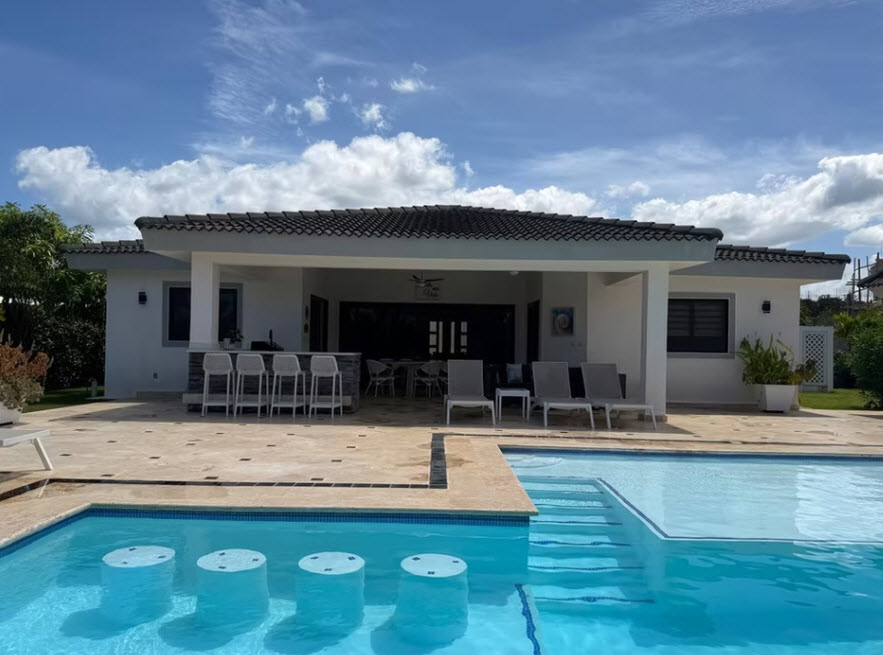Modern villa with a swimming pool and outdoor bar on a sunny day