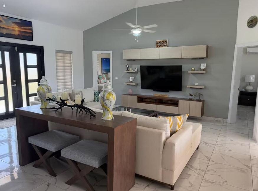 Modern living room with vaulted ceiling, sectional sofa, and entertainment center