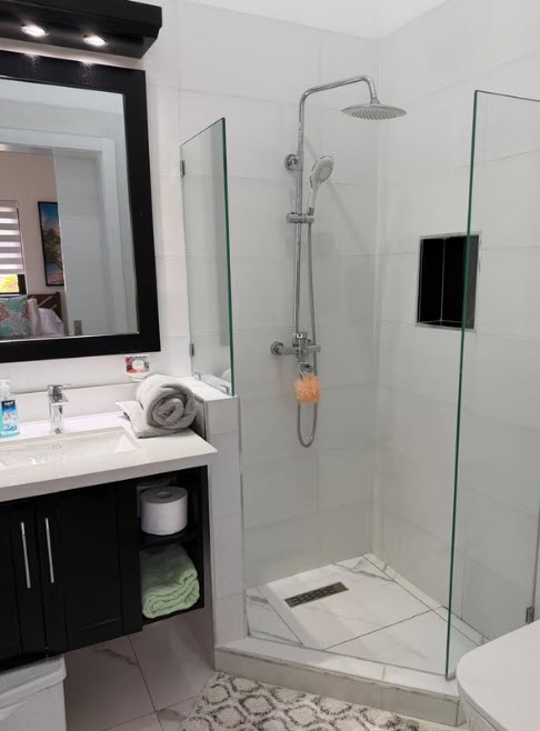 Modern bathroom with walk-in shower, vanity, and large mirror
