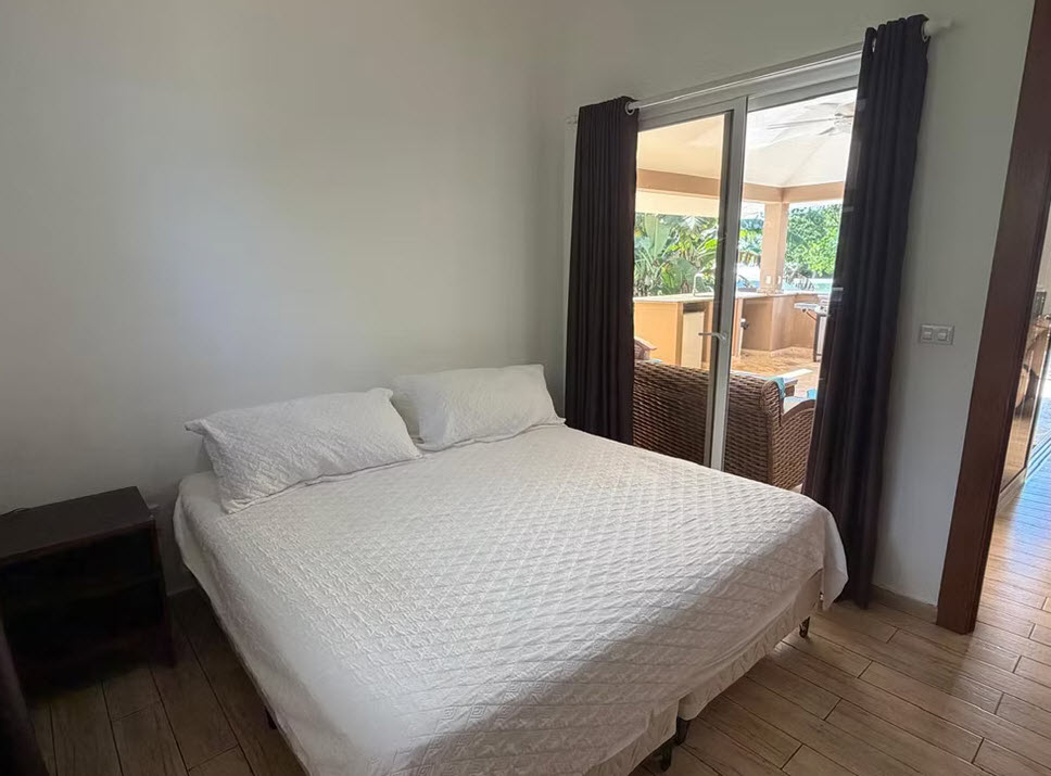 Bedroom with queen bed and sliding glass doors opening to a patio