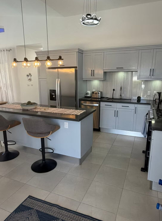 Modern gray kitchen with stainless steel appliances and island seating