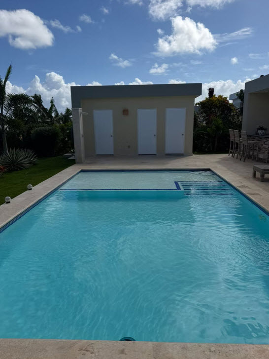 Modern villa with swimming pool and three white doors under blue sky
