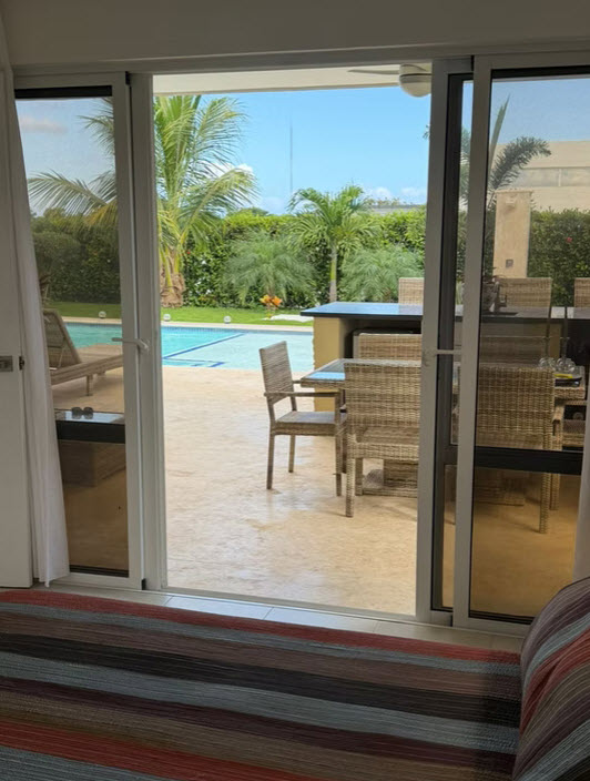 Outdoor patio with swimming pool, lounge chairs, and dining set