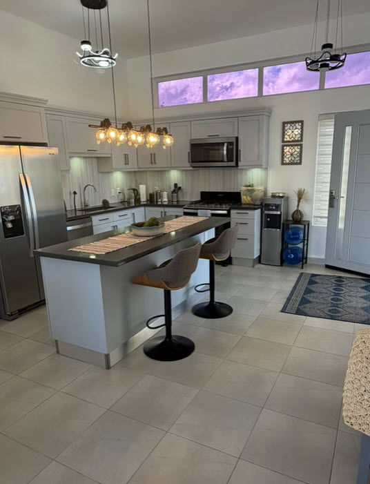 Modern kitchen with island, stainless steel appliances, and pendant lighting