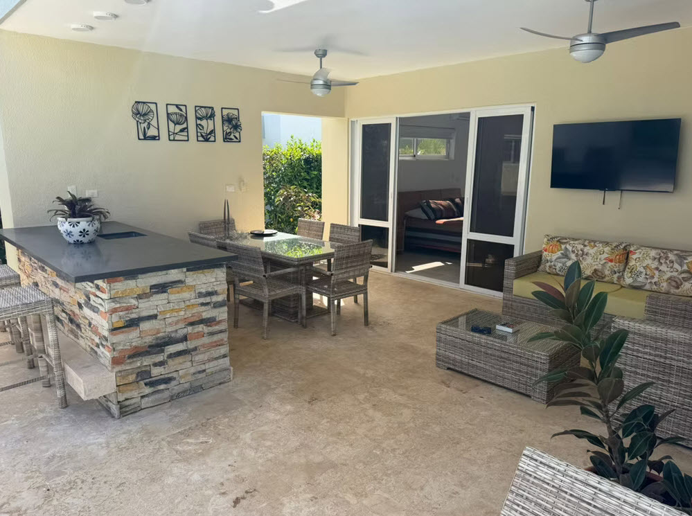 Outdoor patio with bar, dining table, and lounge area