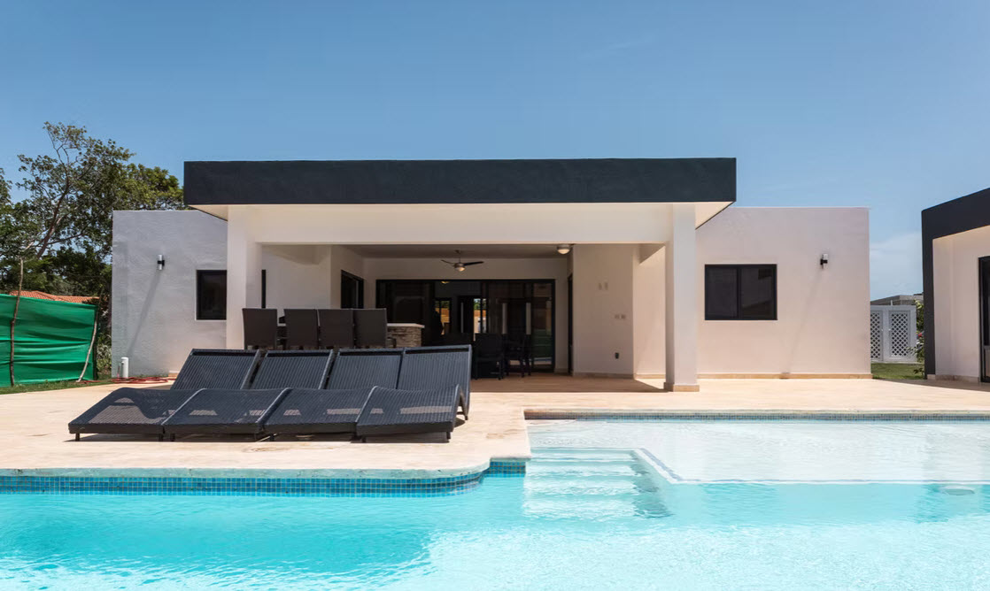 Modern white villa with a swimming pool and lounge chairs